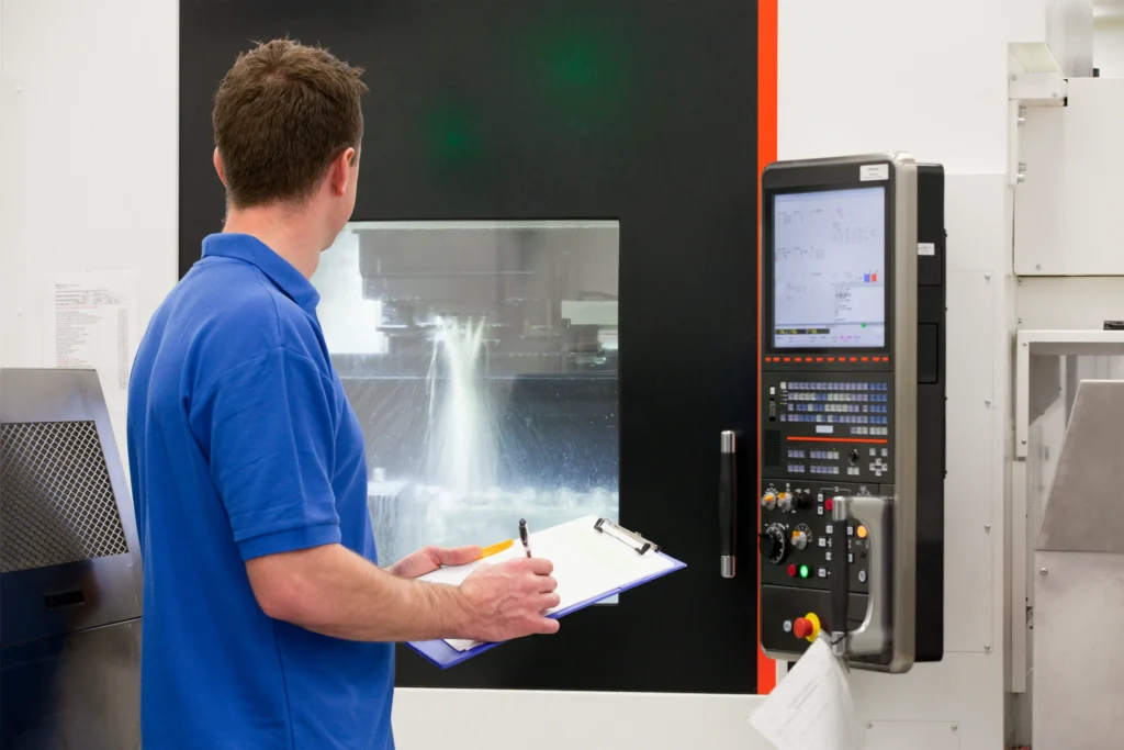 Man Inspecting Industrial Equipment Oil Mist, Concentration & Tank Maintenance in a Factory